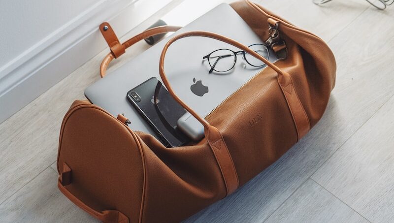 silver MacBook in duffel bag
