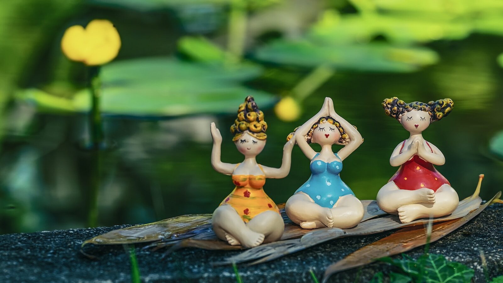 three little figurines are sitting on a leaf