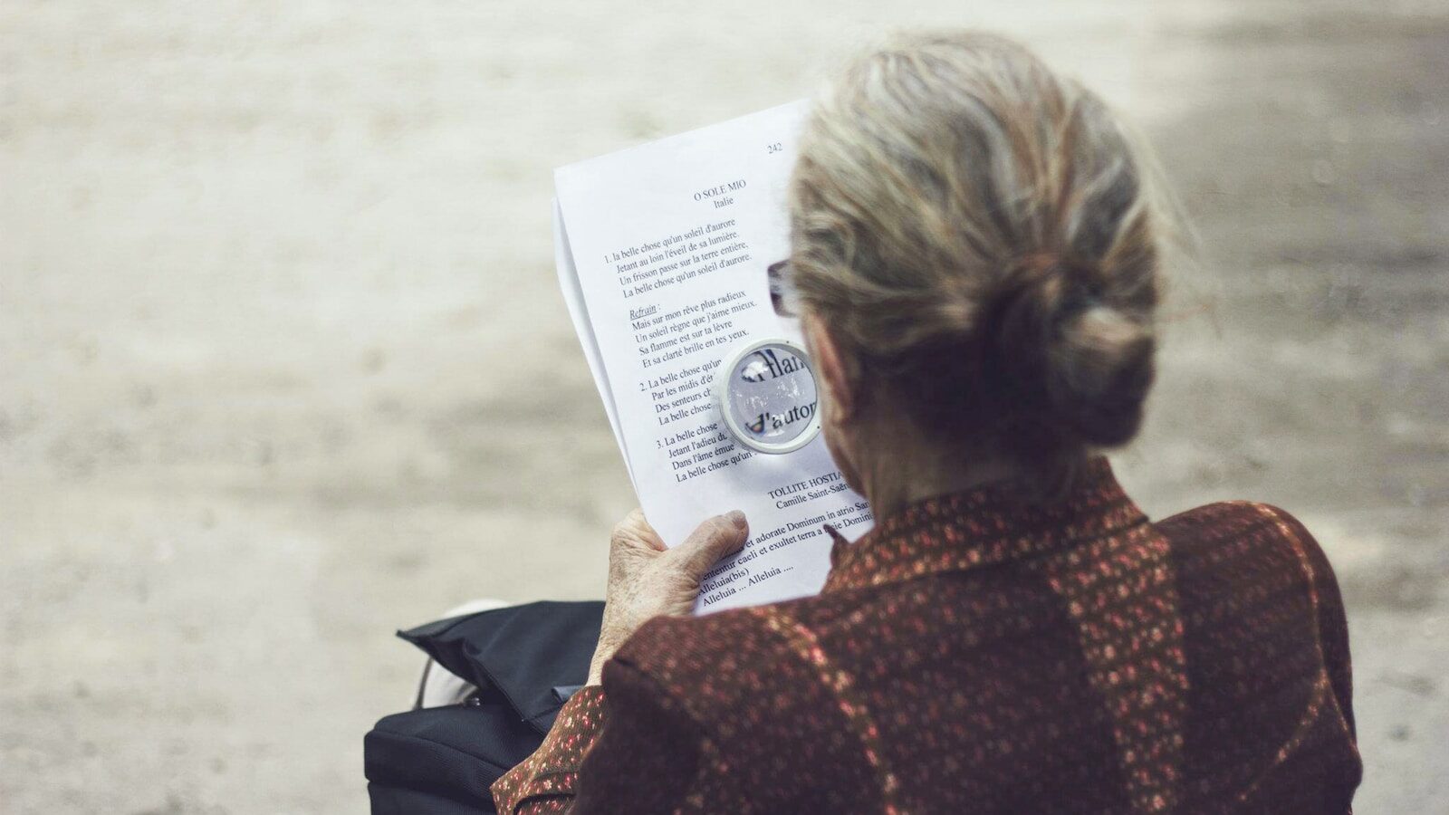 woman in brown top reading paper